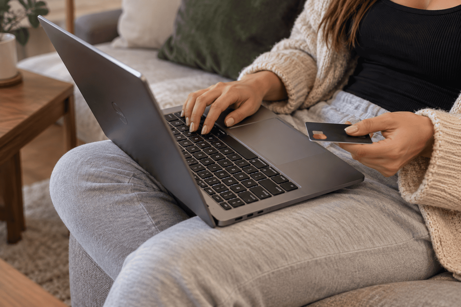 Pessoa realizando uma compra online usando um notebook e cartão